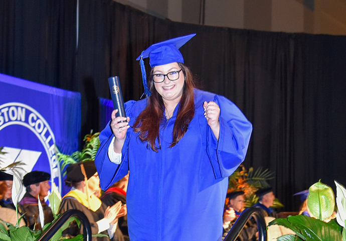 Women excitedly recieves diploma.