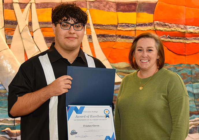 Student poses with award and student's advisor.