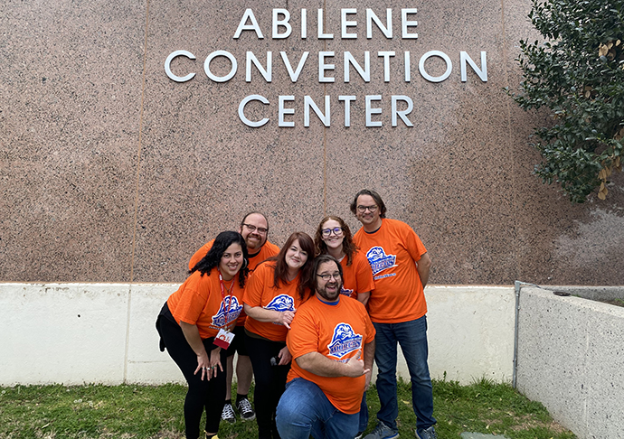 Students stand outside convention center.