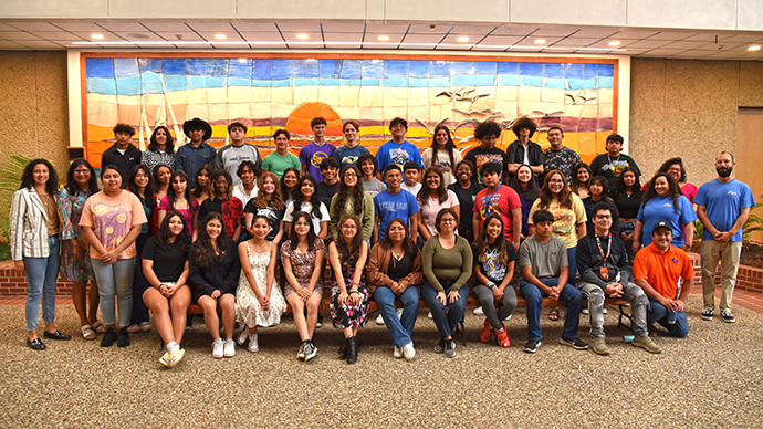 Group of students pose for photo in atrium.