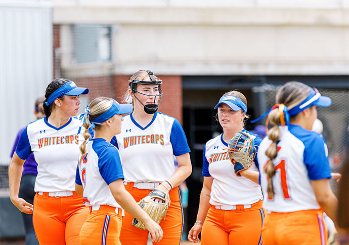 Galveston College Softball players gather together on field