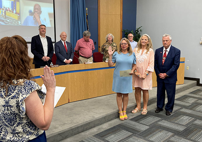 People stand before board in process of being sworn in