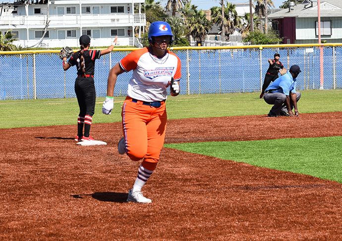 Softball player runs bases.