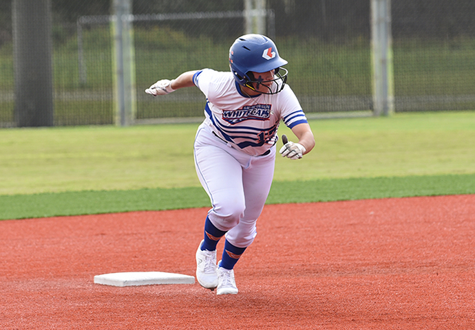 Galveston College Softball player runs third base.