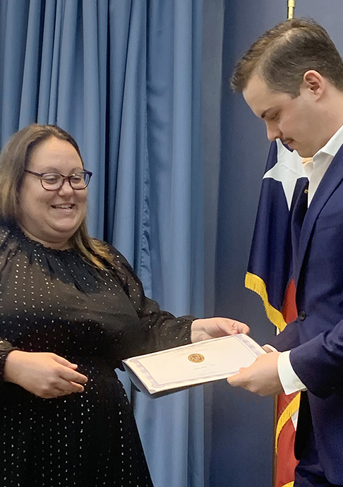 Woman presenting student honors award.